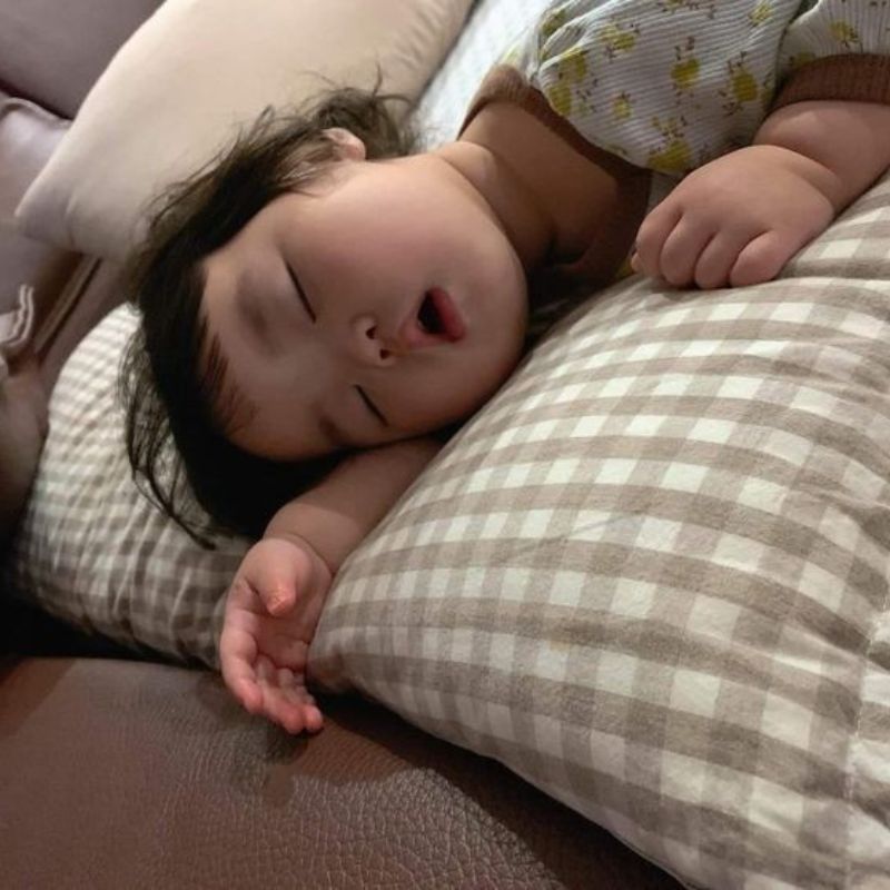 Ảnh em bé nằm sấp ngủ say trên gối, miệng há hốc ngộ nghĩnh