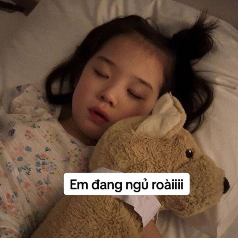 bé gái ôm gấu bông ngủ say kèm dòng chữ em đang ngủ roàiiii