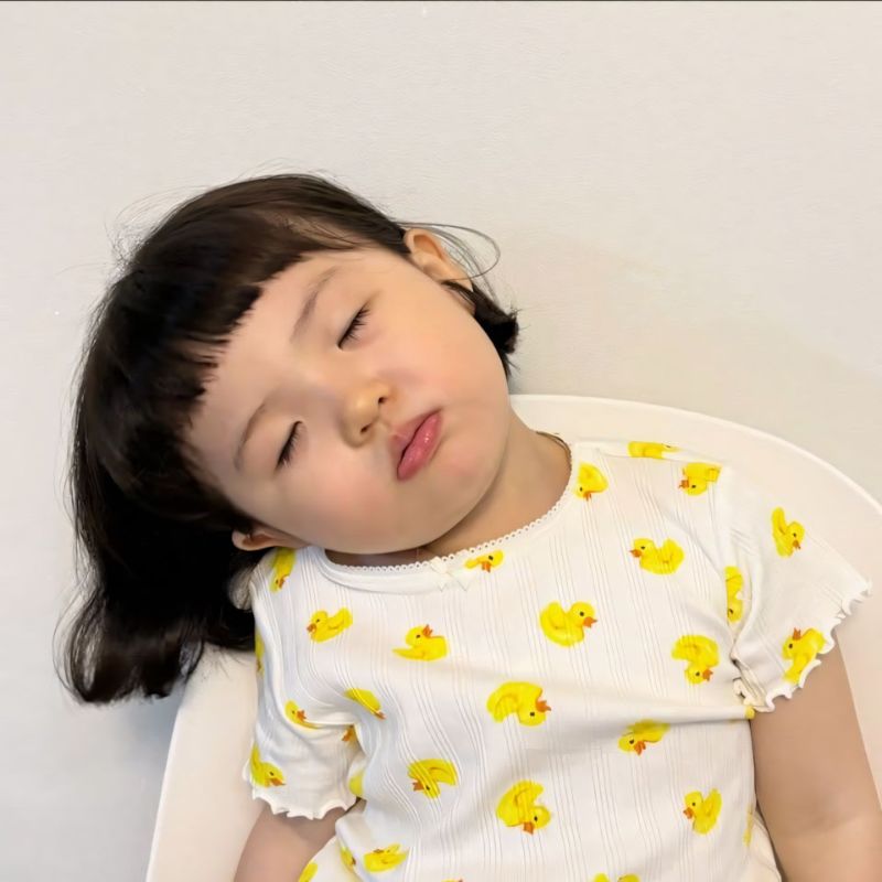meme em bé tóc ngắn mắt nhắm tịt ngái ngủ dựa đầu vào ghế