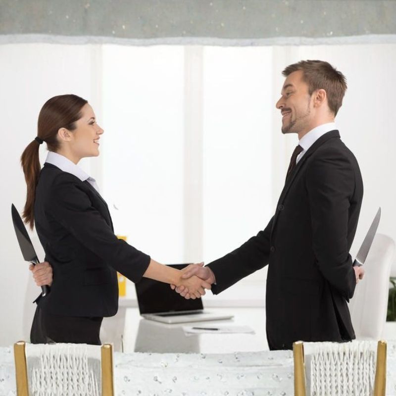 Cặp đôi mặc vest bắt tay nhau nhưng cả hai đều giấu dao sau lưng