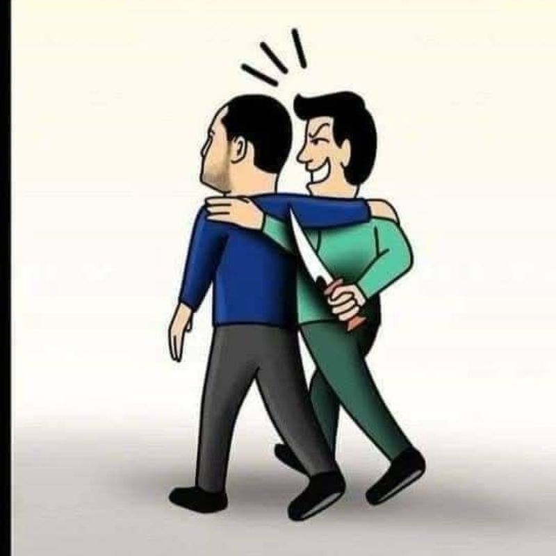 Người đàn ông áo xanh lá cầm dao sau lưng với nụ cười nham hiểm