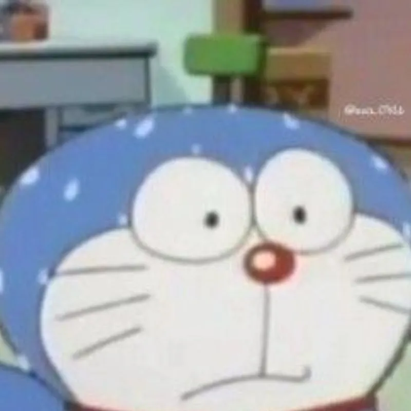 Nhân vật hoạt hình Doraemon với biểu cảm bàng hoàng, mắt mở to tròn trân trân và trên đầu lấm tấm vô số giọt mồ hôi nhỏ