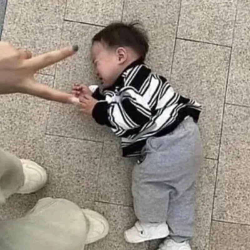 Ảnh meme một em bé nằm khóc trên sàn nhà