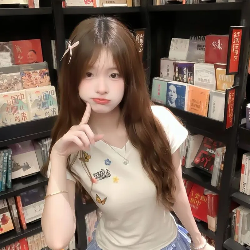 Ảnh đại diện avatar gái xinh k10 phồng má cute, diện áo thun trắng đứng check-in bên kệ sách