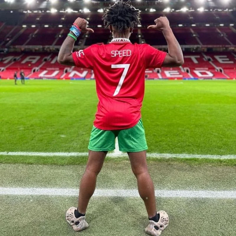 IShowSpeed mặc áo đấu in tên Speed số 7 quay lưng tạo dáng ăn mừng "Siuuu" tại sân vận động Old Trafford.