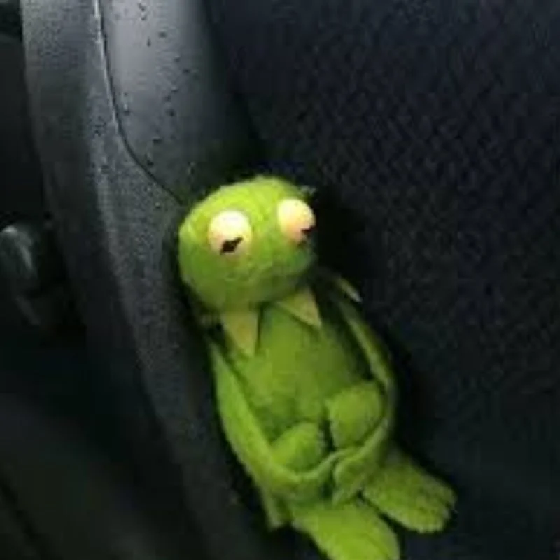 Ếch Kermit buồn bã gục đầu ngồi dựa vào ghế xe hơi, thể hiện sự chán nản