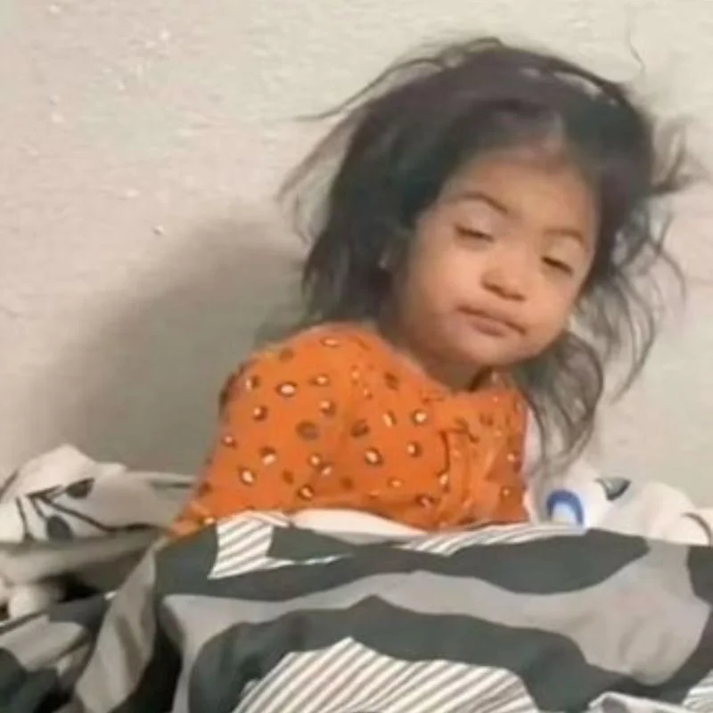 Ảnh em bé tóc tai bù xù, mắt nhắm mắt mở, biểu cảm ngơ ngác khi vừa ngủ dậy.