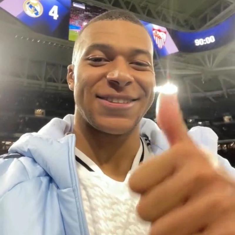 Cầu thủ Kylian Mbappe đang mỉm cười và giơ ngón tay cái trước ống kính sân vận động