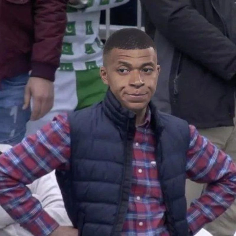 Ảnh chế Kylian Mbappe ghép vào thân người mặc áo sơ mi kẻ sọc đang chống hông thắc mắc