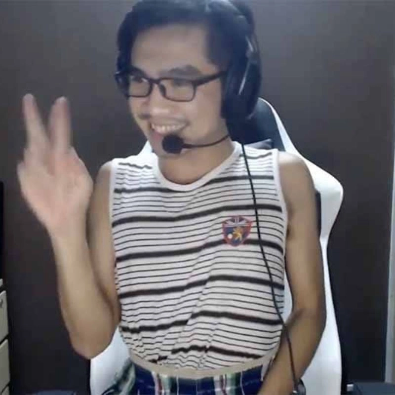 Streamer PewPew mặc áo ba lỗ kẻ sọc đang giơ tay chào trong một buổi livestream