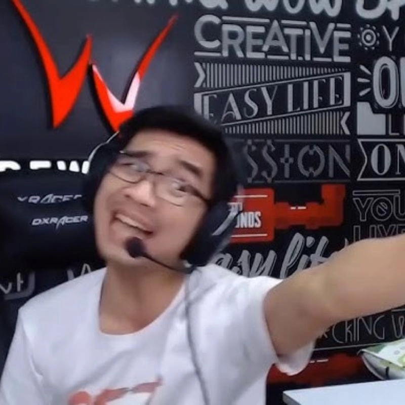 Streamer PewPew với biểu cảm gương mặt đăm chiêu, tay chỉ về một phía trong