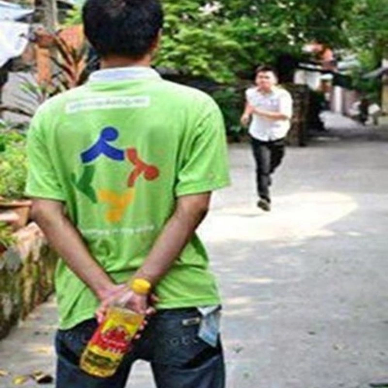 Ảnh meme dầu ăn thanh niên áo xanh giấu chai dầu sau lưng đuổi theo bạn áo trắng