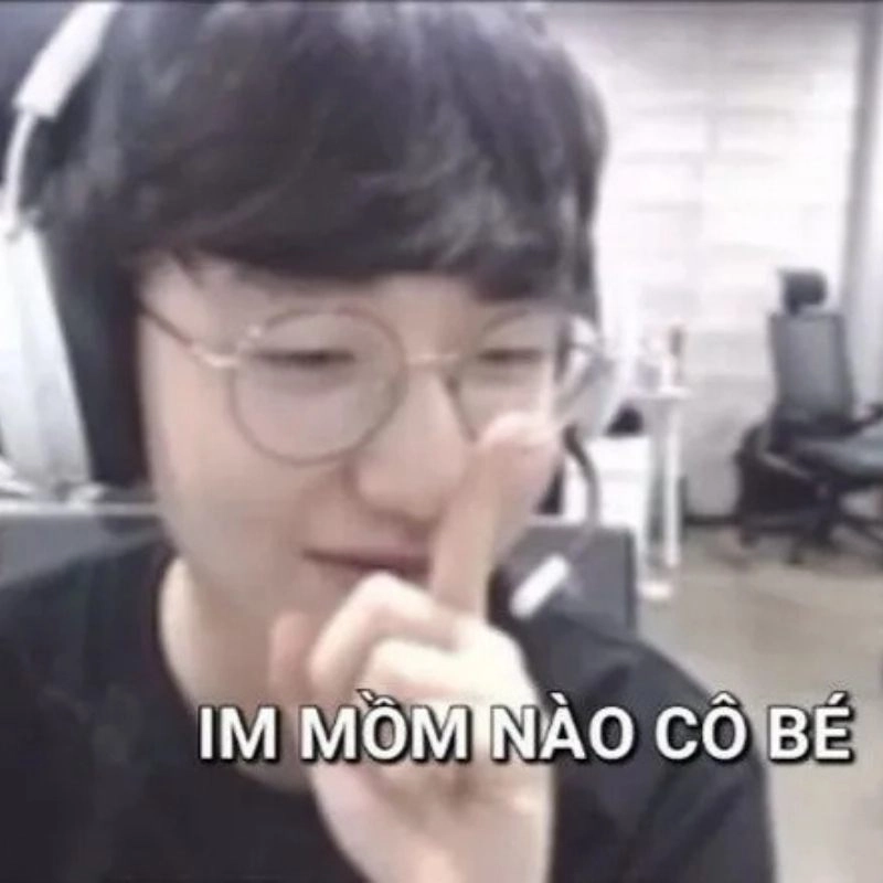 Ảnh meme tuyển thủ Faker đeo tai nghe giơ ngón tay lên môi bảo im lặng hài hước
