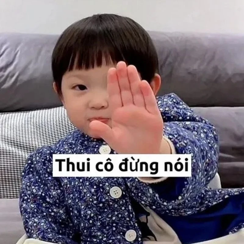 Em bé gái mỉm cười giơ bàn tay ra trước ra hiệu dừng nói